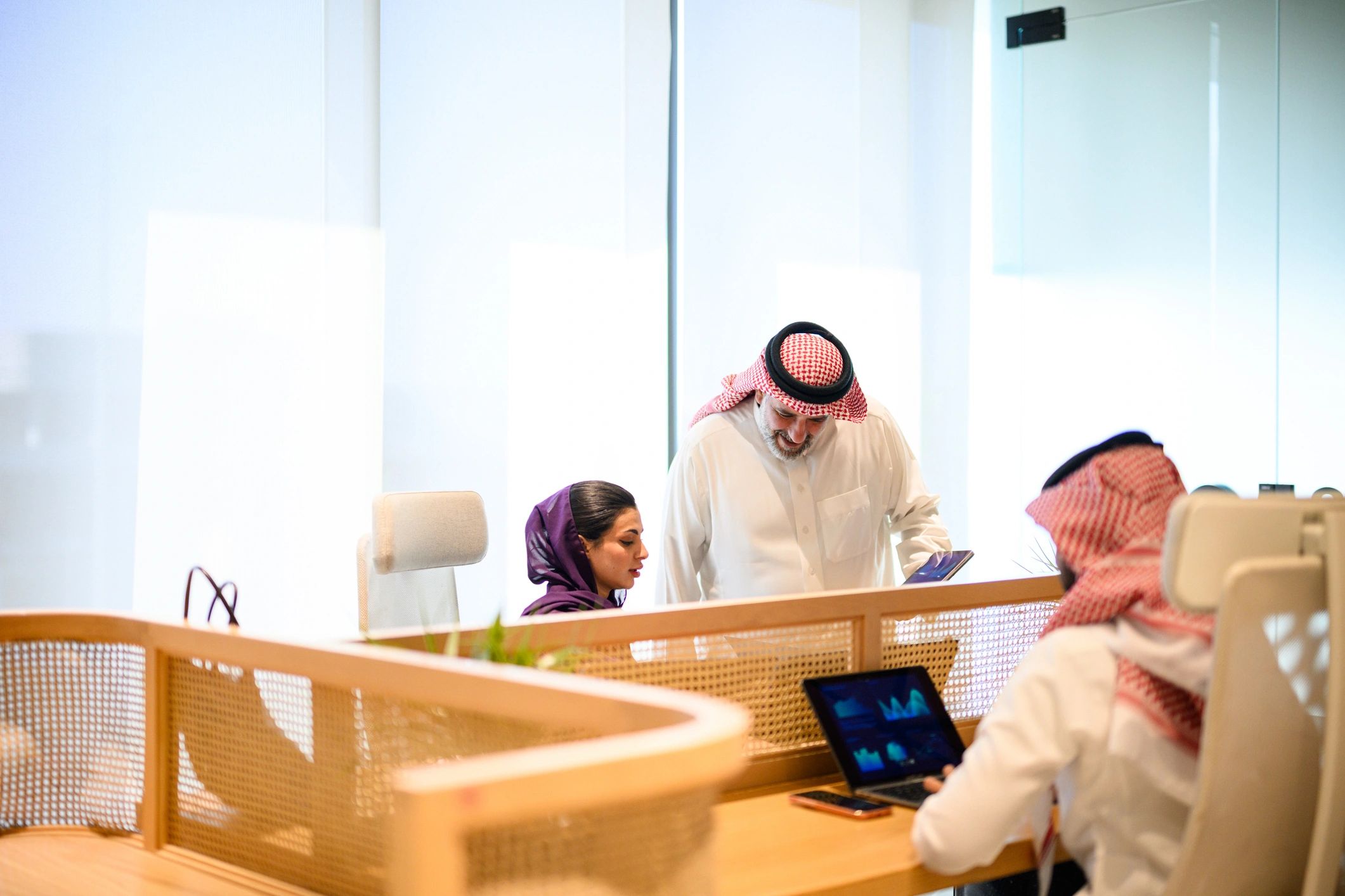 Saudi business professionals collaborating in a modern office